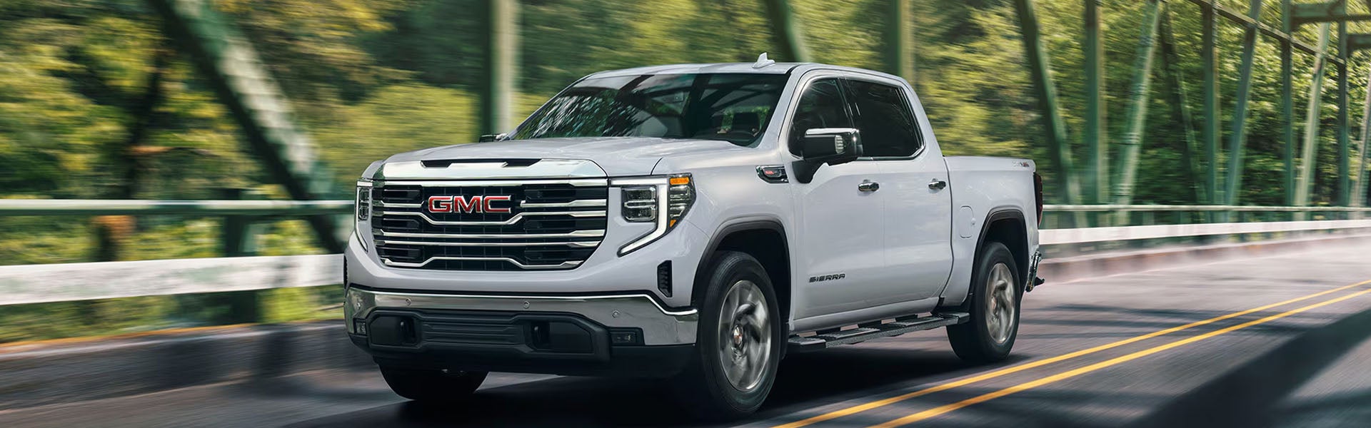GMC Sierra pickup truck driving on a road.